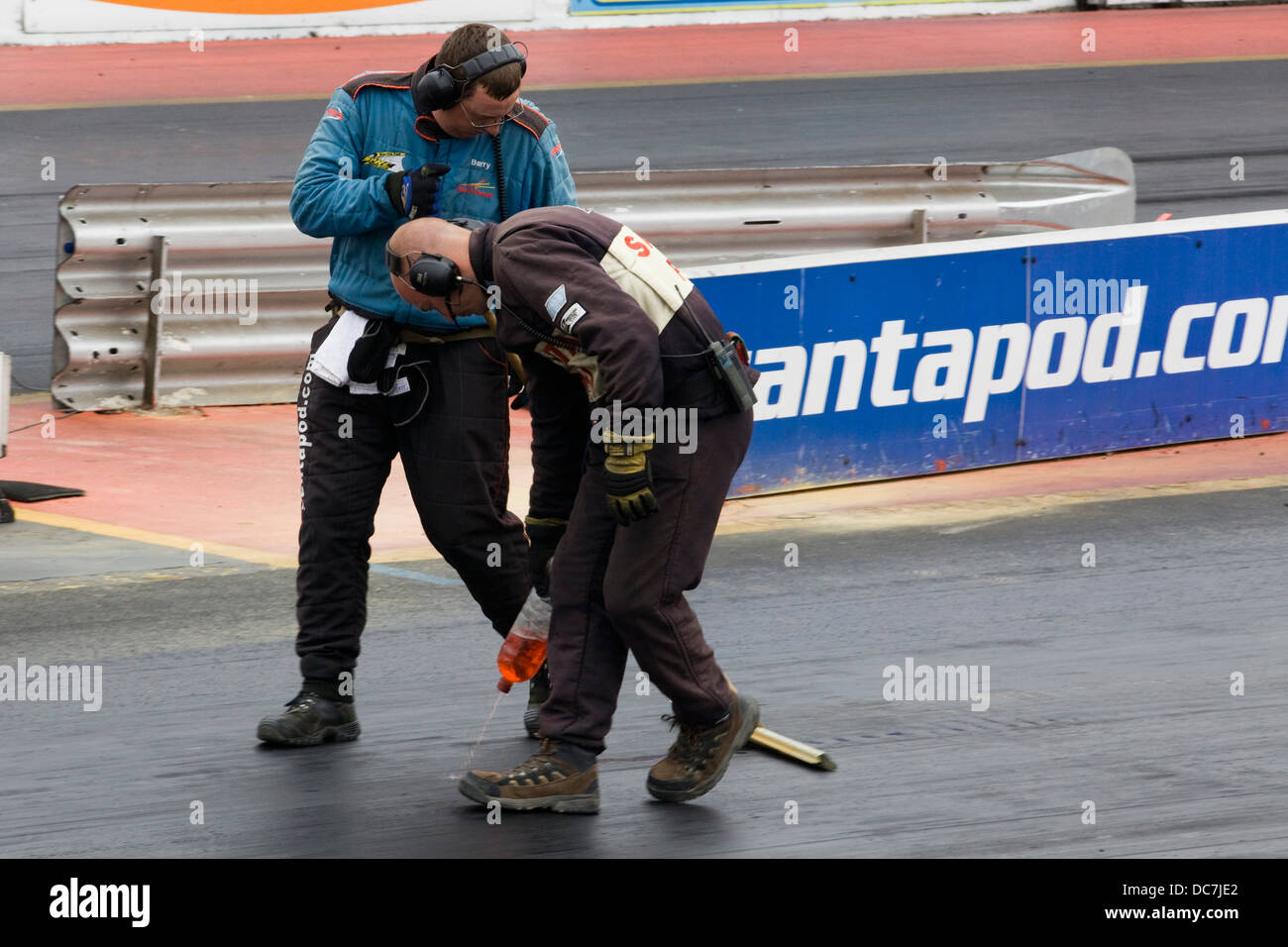 Track assistants making sure the race track is clean of Debris before the jet car goes up Stock