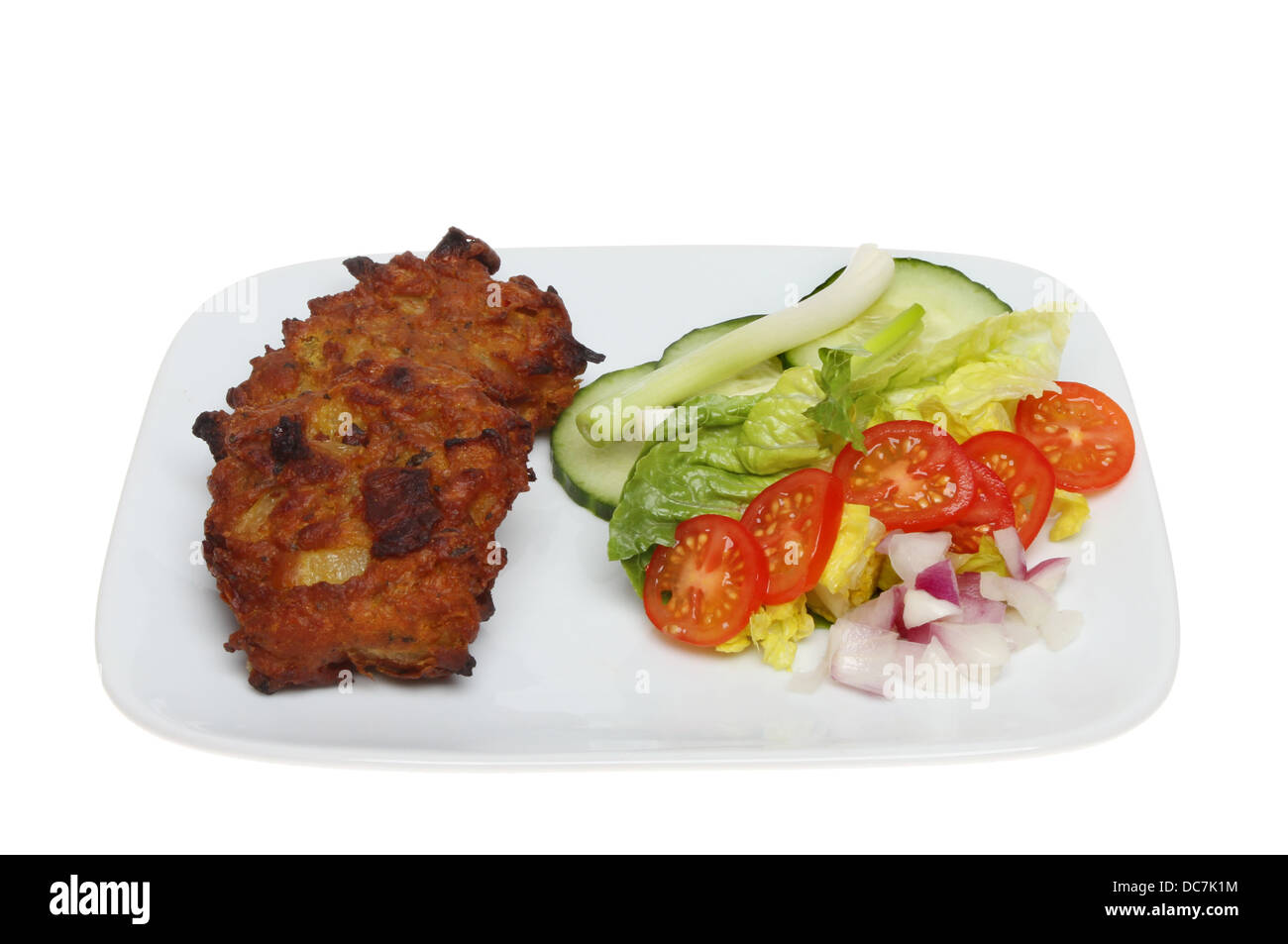 Onion Bhaji With A Salad Garnish On A Plate Isolated Against White onion-bhaji-with-a-salad-garnish-on-a-plate-isolated-against-white