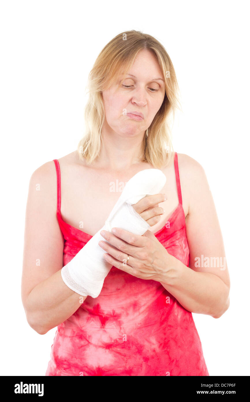 Mature woman looking sad at her bandaged finger Stock Photo