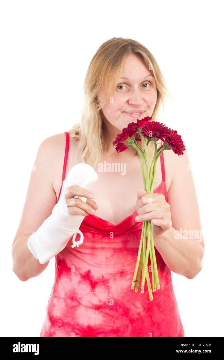Woman with bandaged hand sniffs at flowers Stock Photo