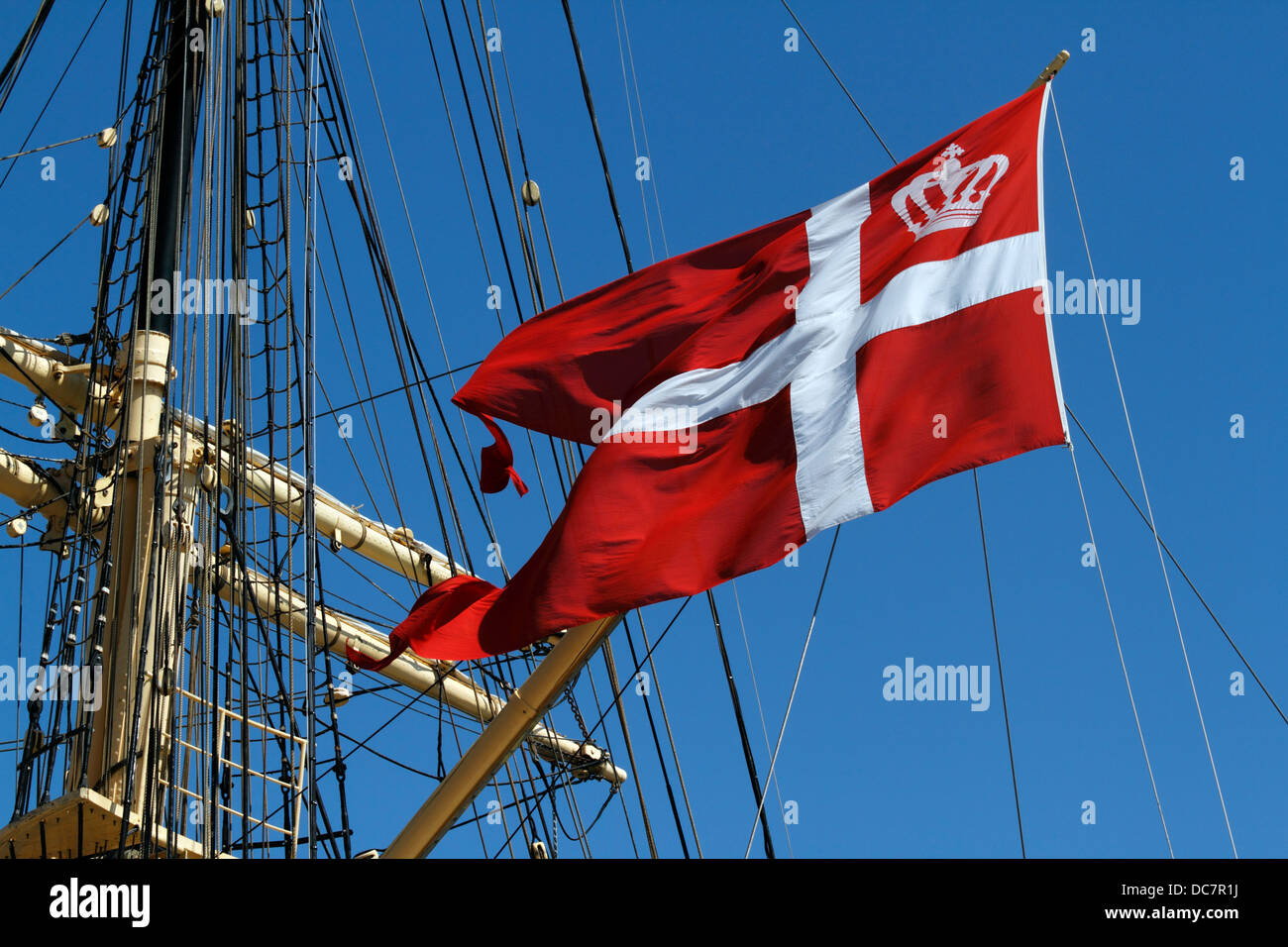 The official swallow-tailed Danish flag, the Dannebrog, on old tall ship, the Danish training ship DANMARK moored in Copenhagen Stock Photo