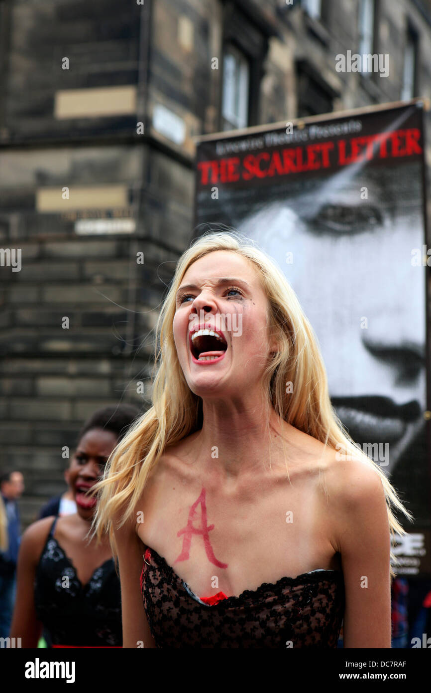 Edinburgh, UK. 11th Aug, 2013. Actors from the Livewire Theatre perform on the Royal Mile enticing people to attend their performance of The Scarlet Letter between 11-17 August. The play is set in 1603 in Salem Massachussets A town torn apart by suspicion. Whispers in the shadows, rumours in the dark. A woman: Accused, Condemned, Branded. The A branding is for Adultery Credit:  PictureScotland/Alamy Live News Stock Photo