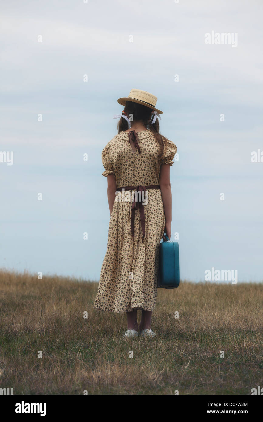 a girl in a vintage dress with suitcase Stock Photo