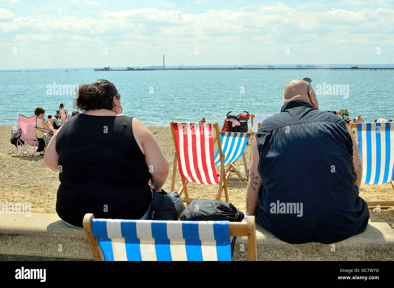 Rear viewpoint of obese couple sitting on Southend seafront Stock Photo