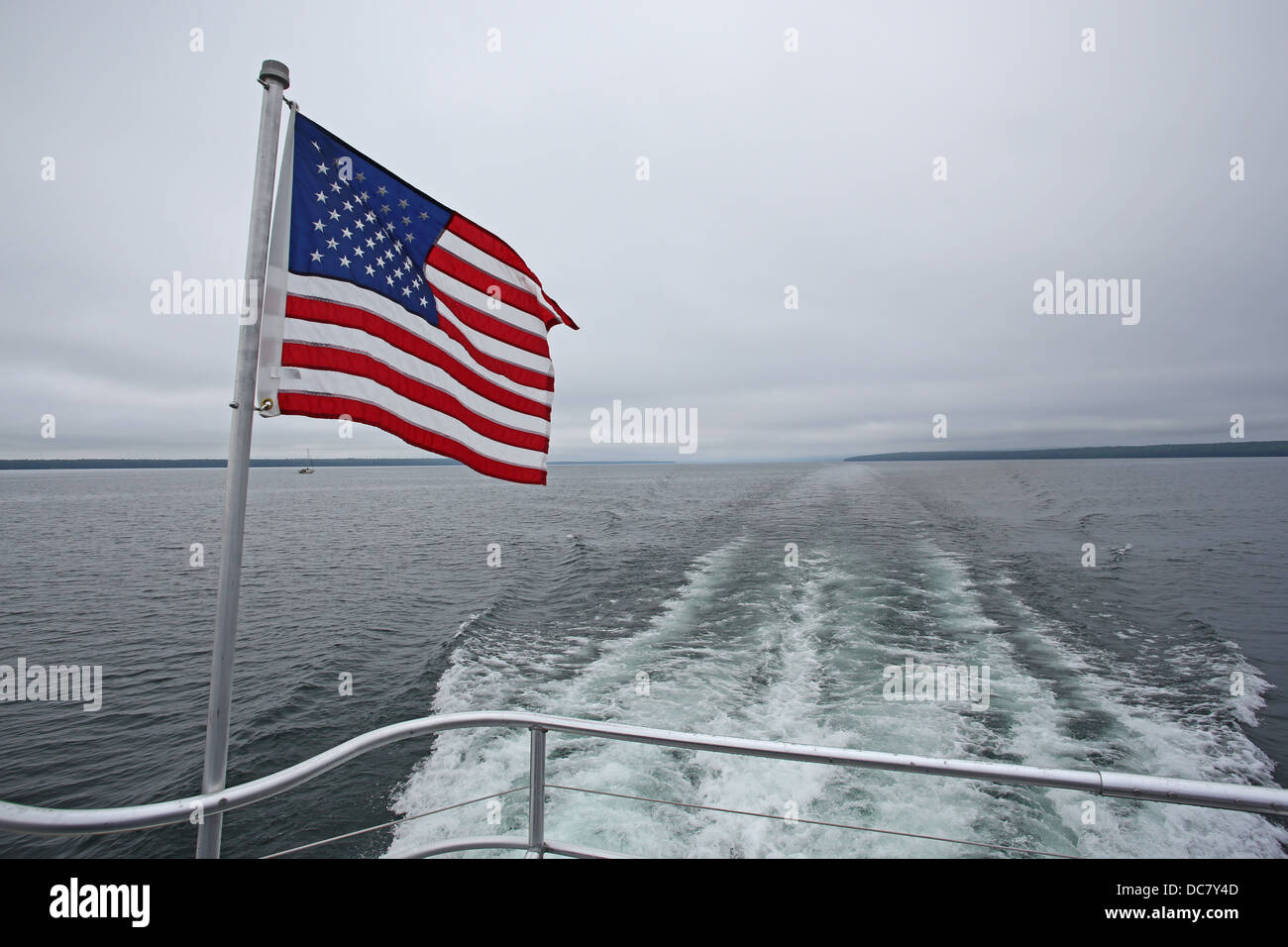 The back of a boat with a fluttering USA flag. Stock Photo