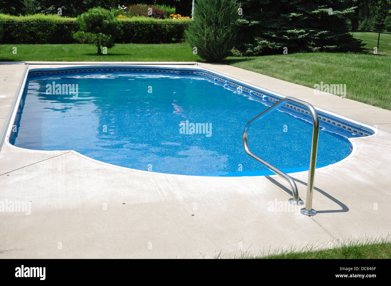 Swimming pool in the garden at home on a sunny summer day Stock Photo
