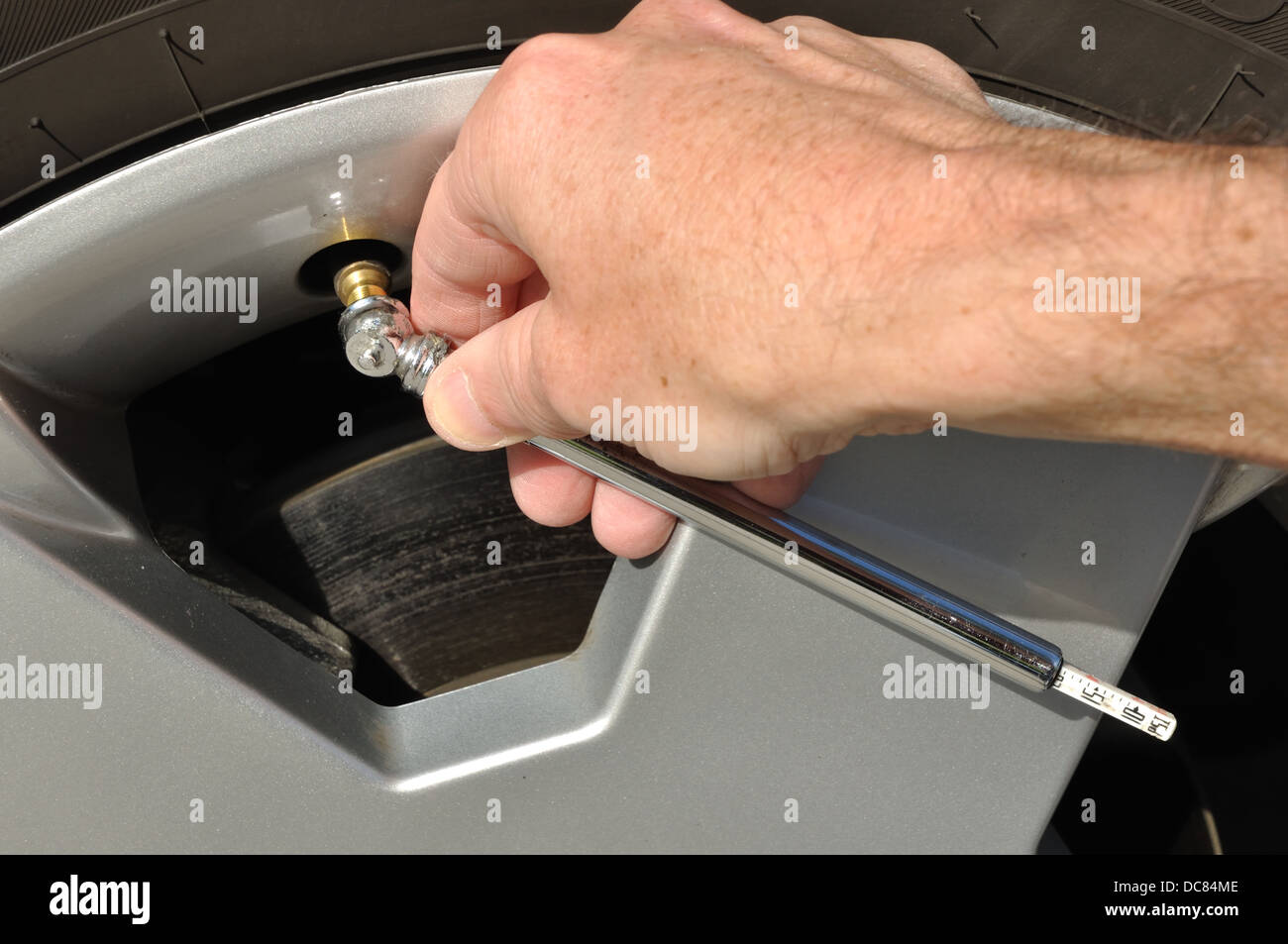 Checking tyre / tire pressure Stock Photo Alamy