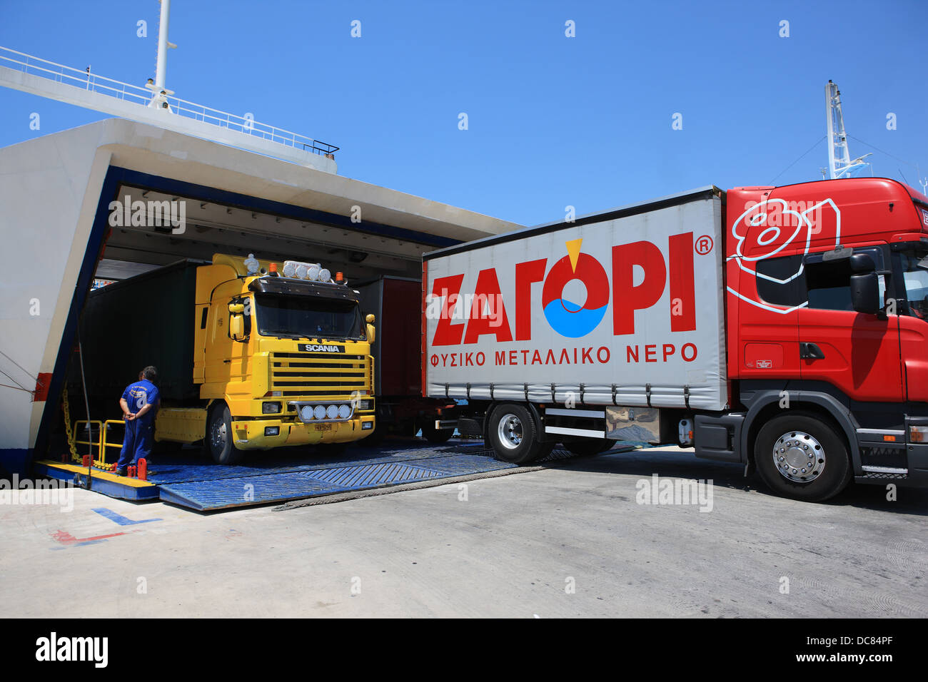 Transport lorries exiting a ferry in the Greek port of Igoumenitsa. ΖΑΓΟΡΙ (ZAGORI) is a Greek bottled water company. Stock Photo