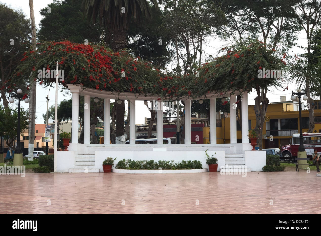 Permanent outdoor stage with columns covered by red Bougainvillea Stock Photo