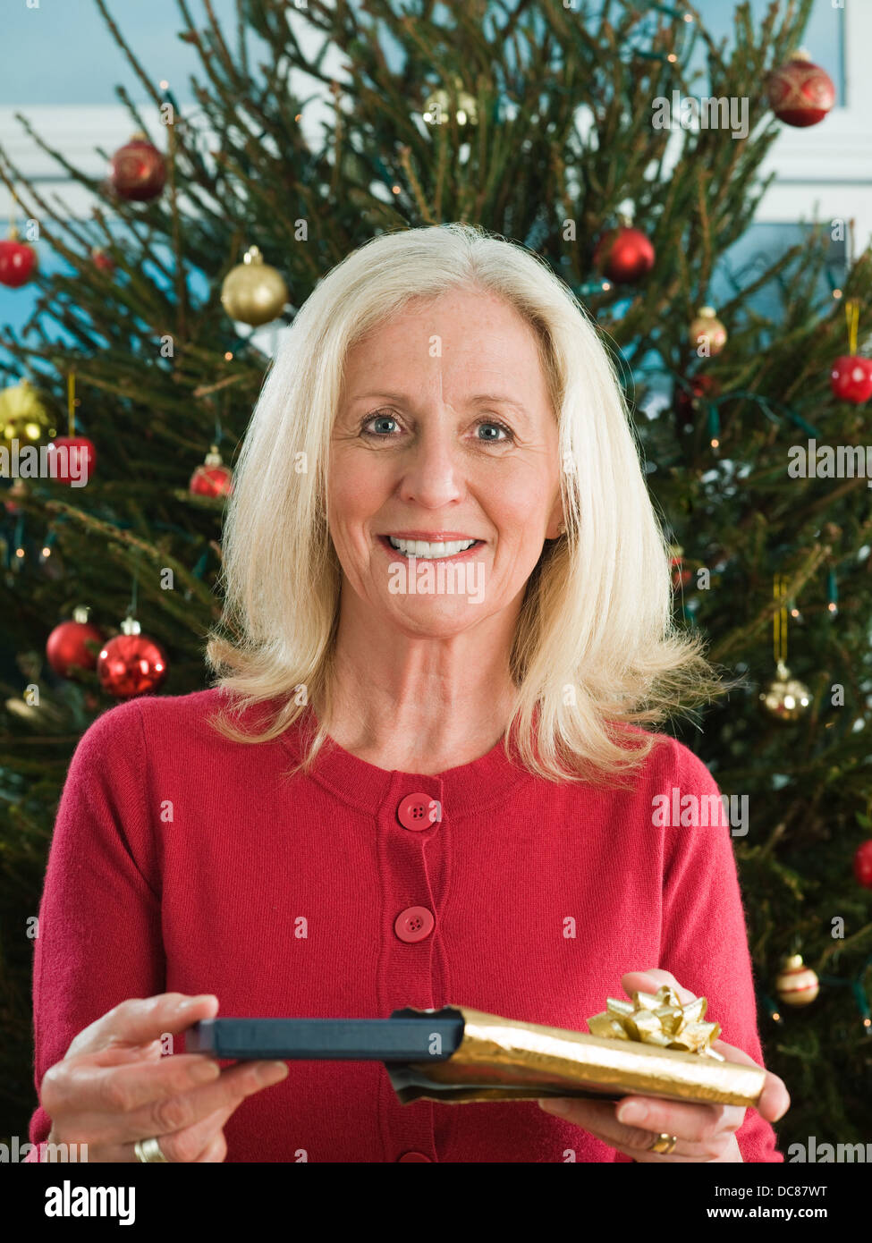 woman holding unwrapped christmas gift Stock Photo