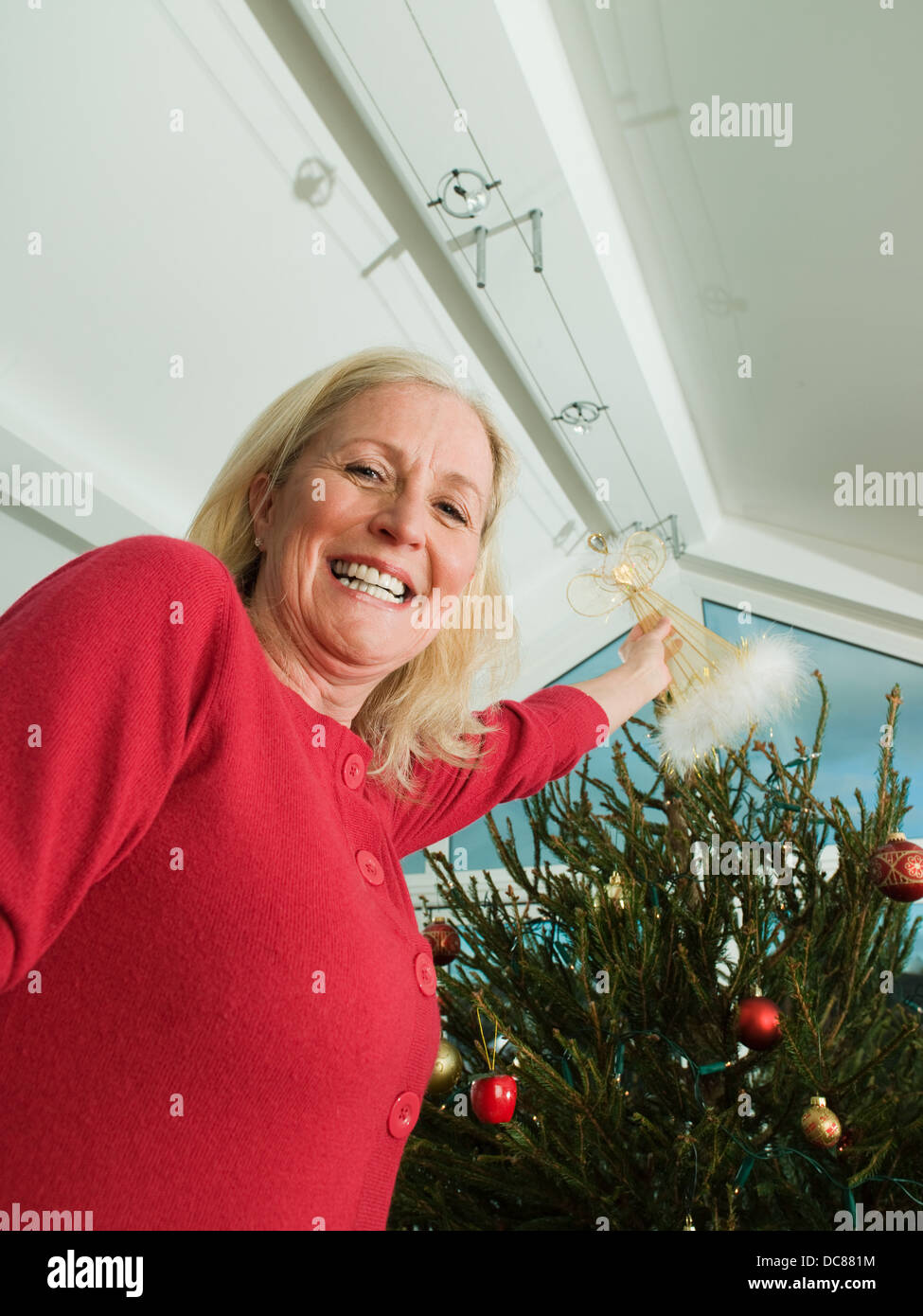 putting angel on top of christmas tree Stock Photo Alamy