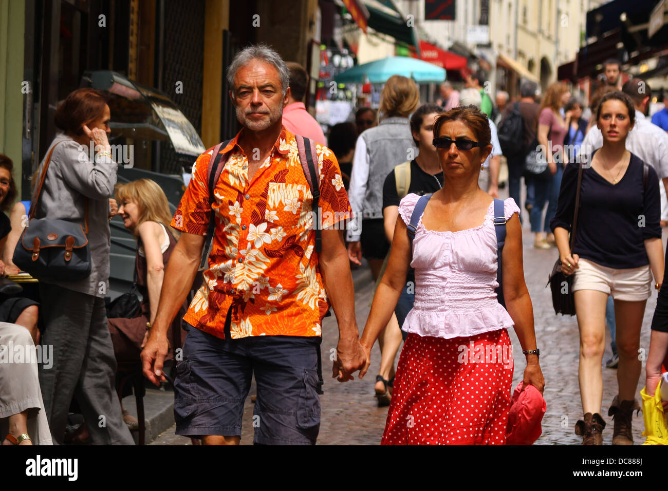 Couple of tourists walking hand by hand through the crowd at rue Mouffetard, Latin Quarter, Paris, France Stock Photo