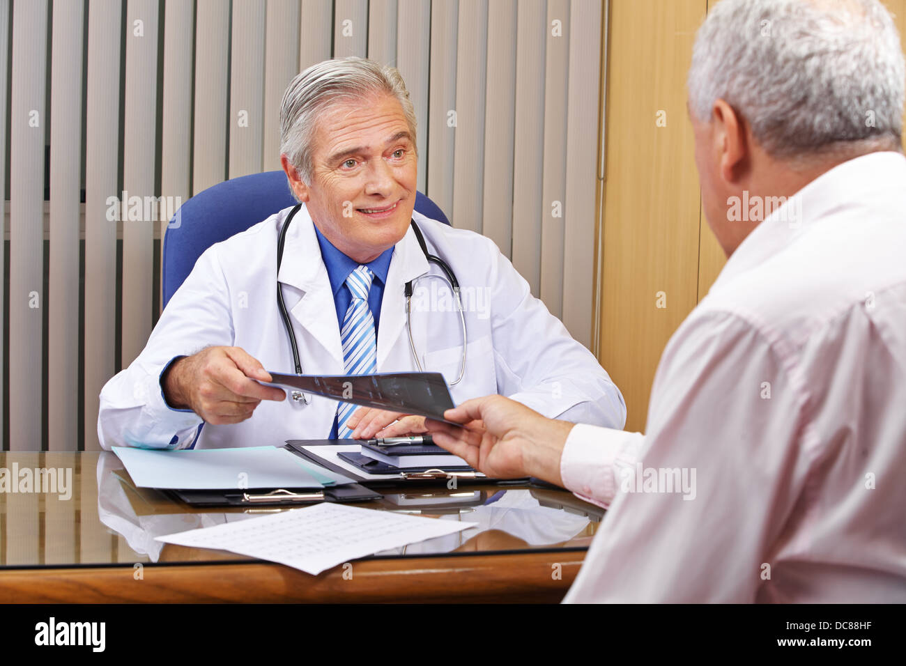 Patient giving his doctor x-ray images from the radiology Stock Photo
