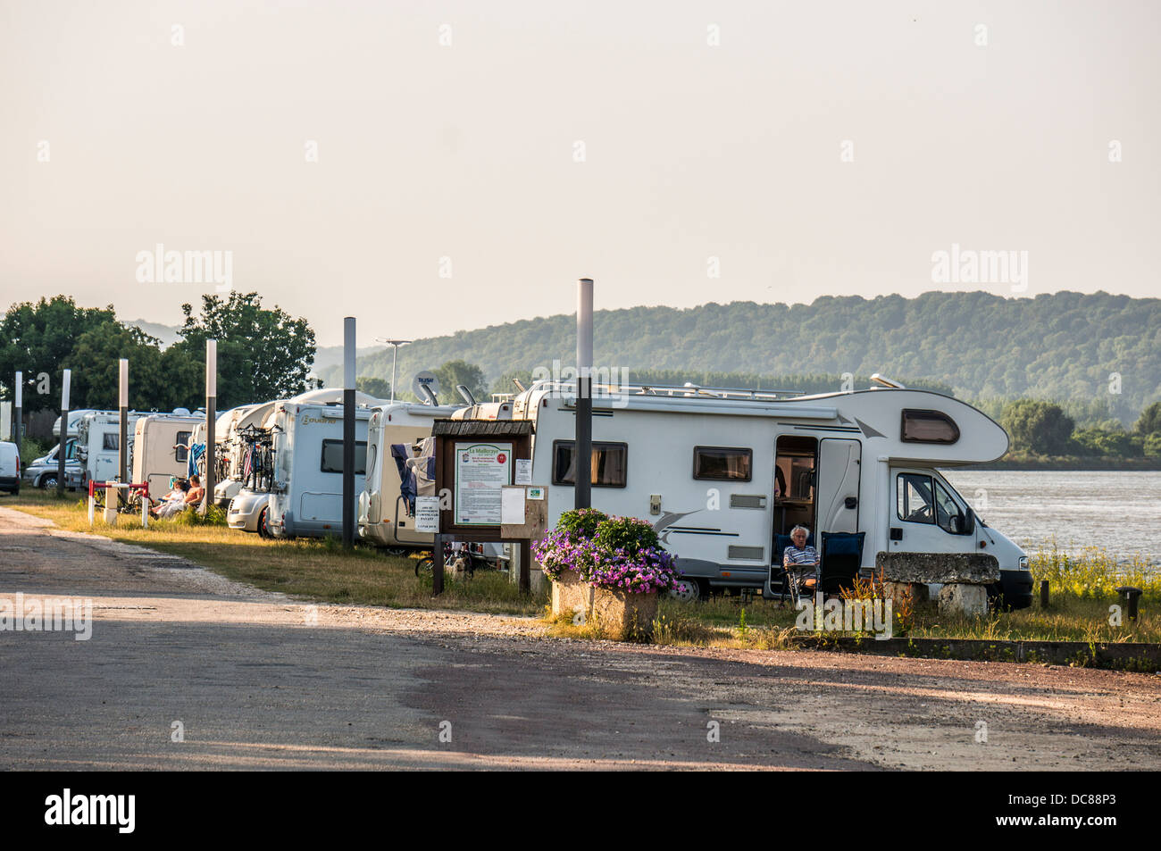 Motorhomes on an aire de campingcar next to river in La Maillerayesur