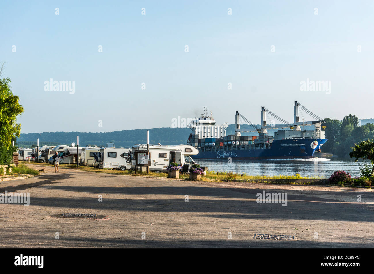 Motorhomes on aire de camping-car, with passing ship on river. La Mailleraye-sur-Seine, Seine-Maritime department, Haute-Normandie, northern France. Stock Photo