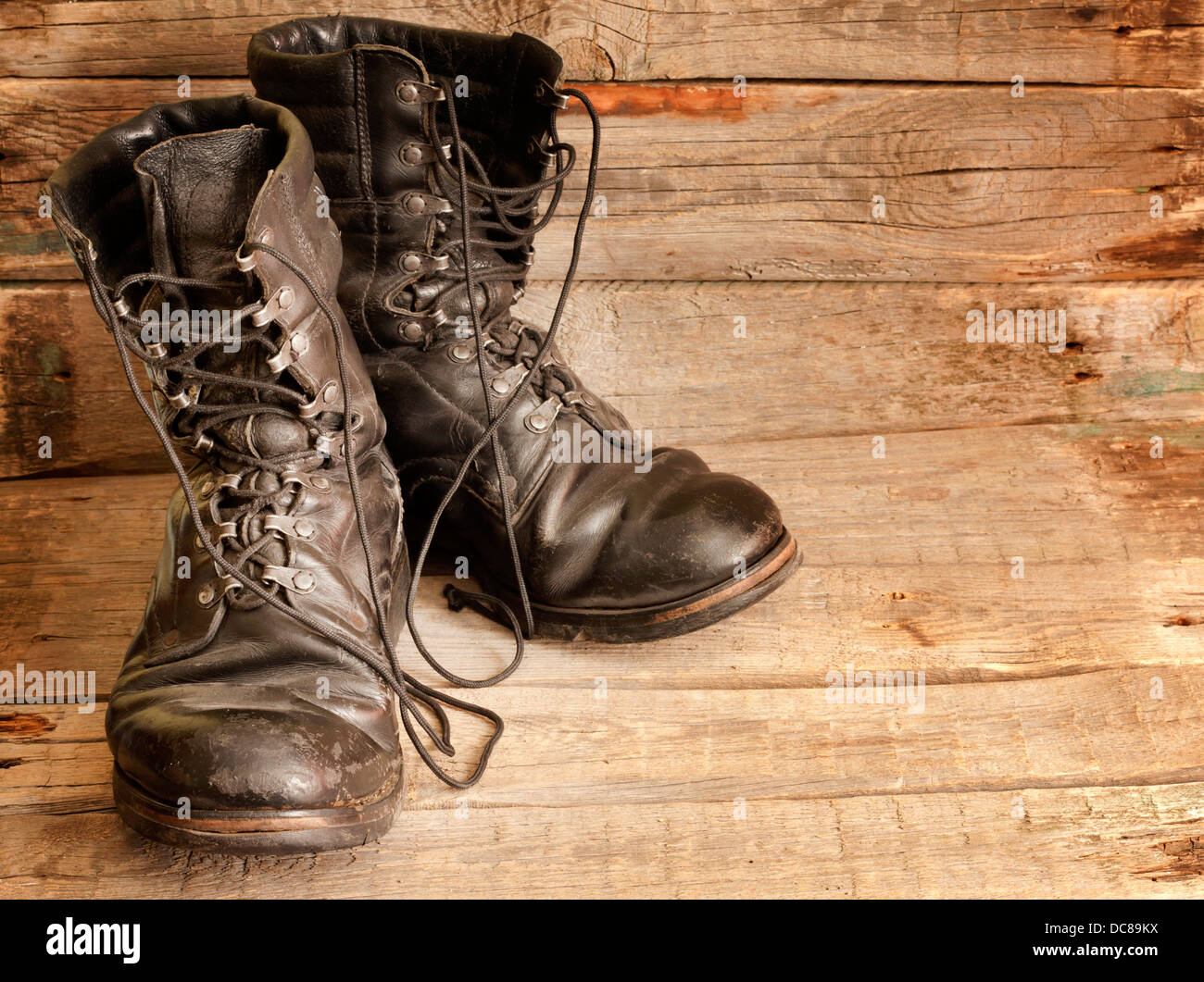 Old military shoes on vintage wooden boards abstract background Stock Photo