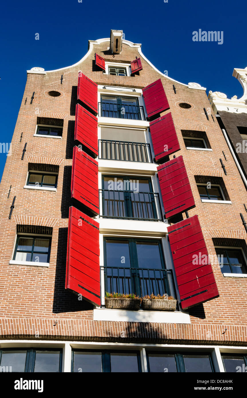 Red window shutters on a house in Amsterdam Stock Photo