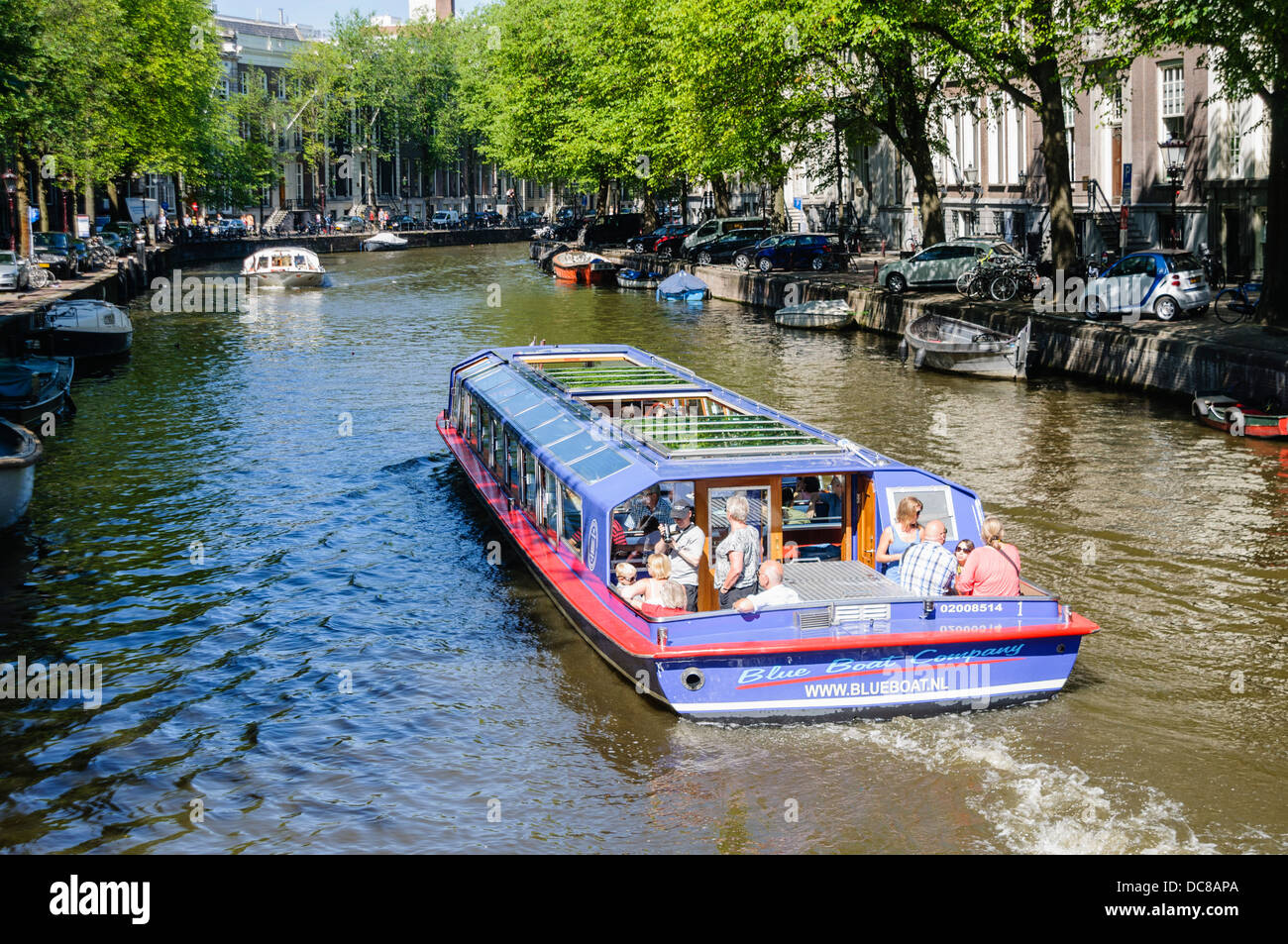 Canal boats in Amsterdam taking tourists Stock Photo