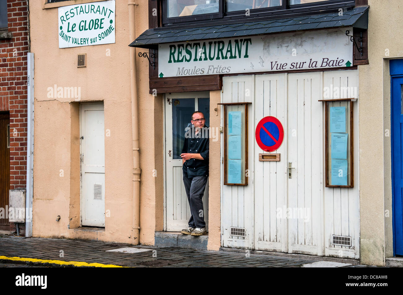 Man Smoking Outside His Restaurant In Saint Valery Sur Somme A
