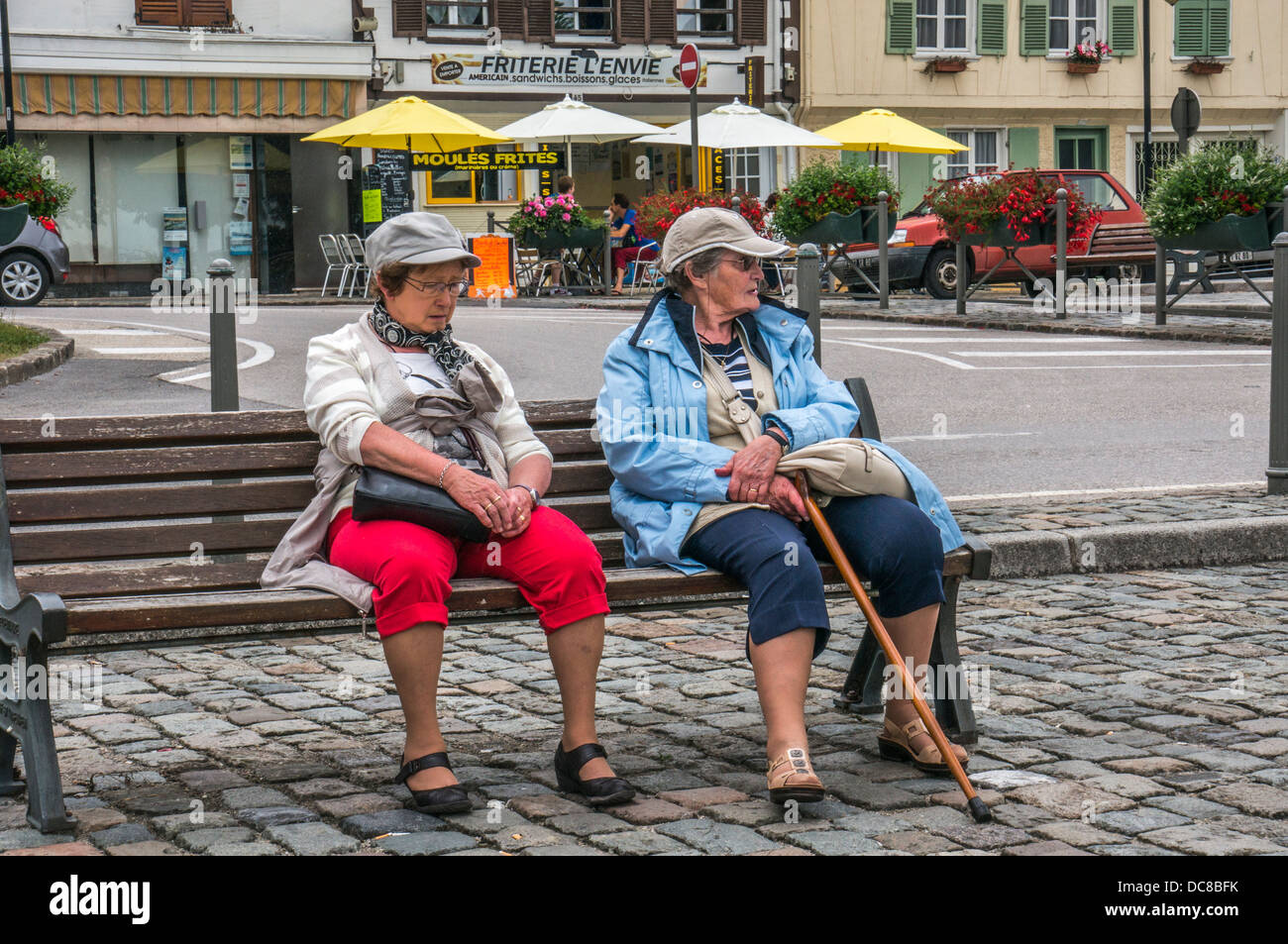 Two old ladies sitting on a bench in Saint-Valery-sur-Somme, a commune in the Somme department, northern France. Stock Photo