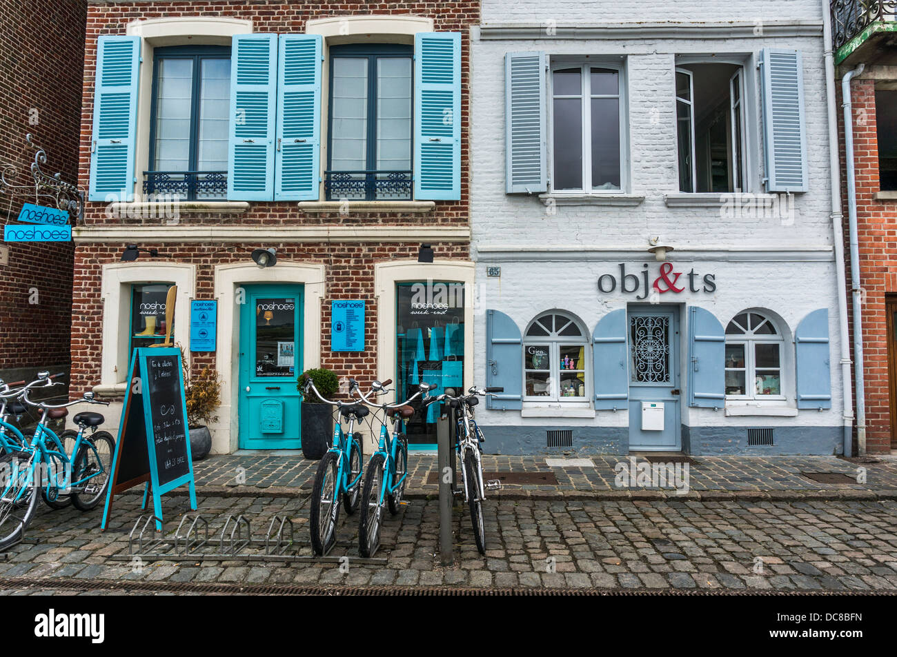 Shops (one with bicycles outside) facing the bay in Saint-Valery-sur-Somme, a commune in the Somme department, northern France. Stock Photo