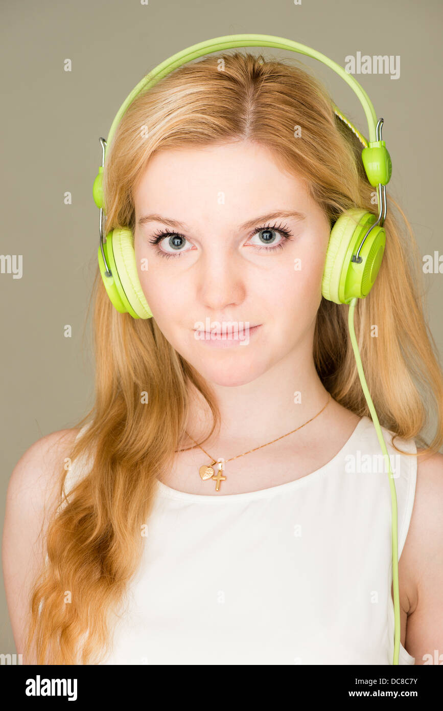 Portrait of young blond female teenager listening to music Stock Photo
