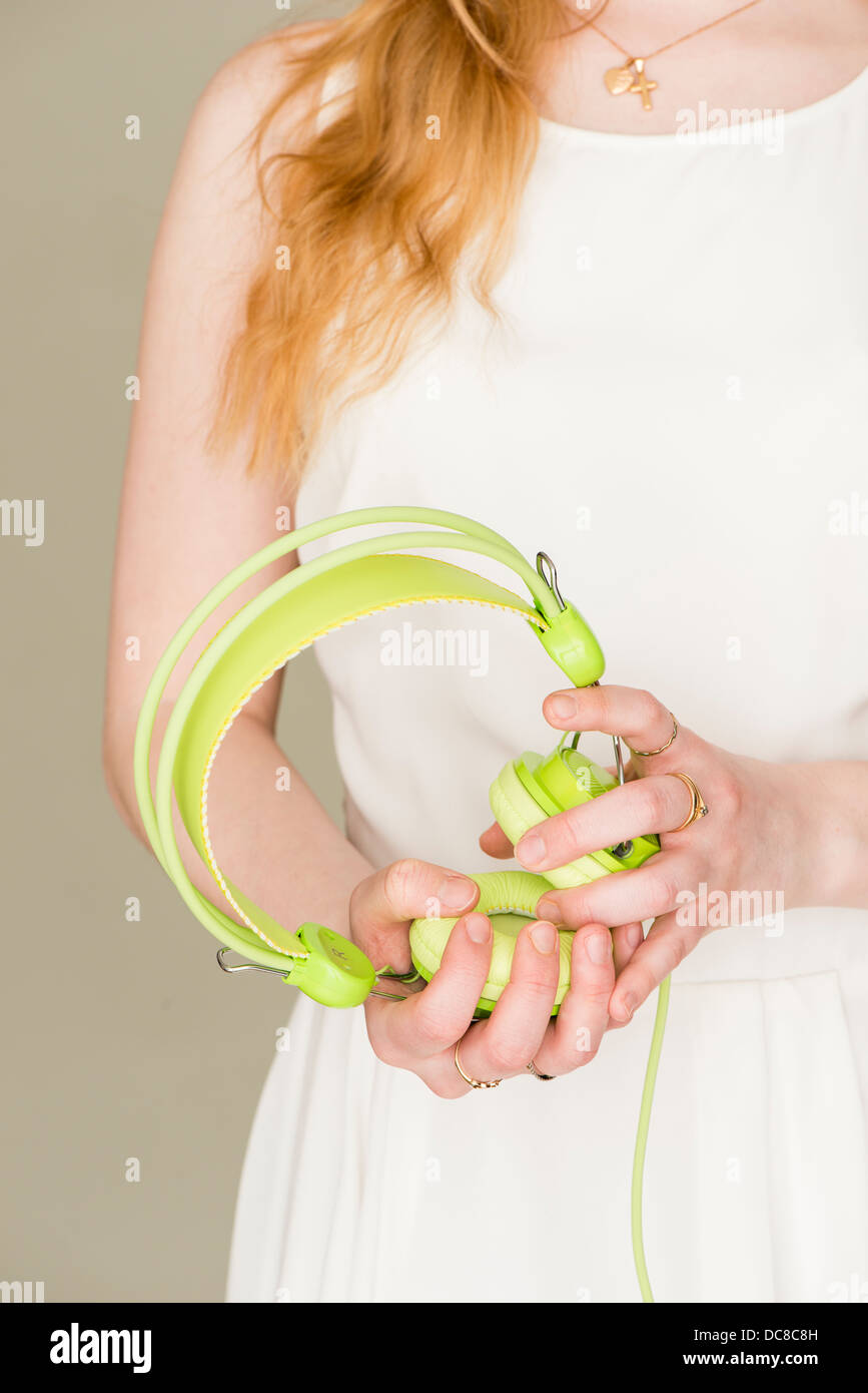 Closeup of young blond female teenager with green headphones Stock Photo