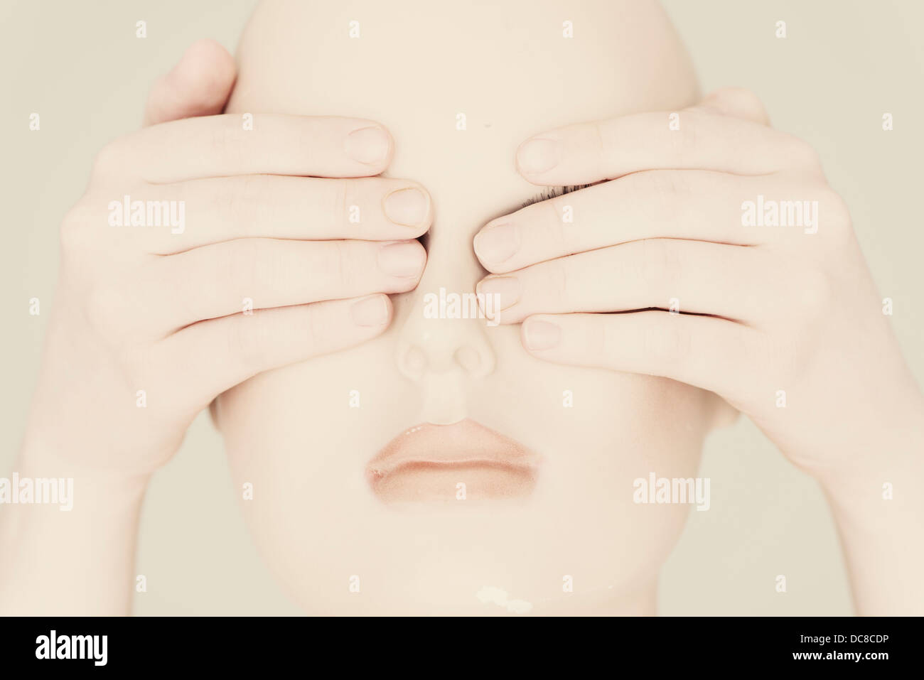 Head of mannequin with human hands covering the eyes Stock Photo