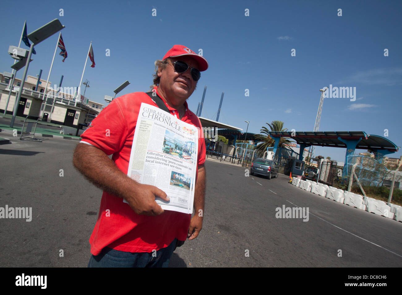 Gibraltar. 12th August 2013. A vendor sells copies of the Gibraltar Chronicle to the public and motorists leaving the Rock. Tensions between Spanish and british governments have been raised after Spain's foreign minister announced he would consider imposing a fee to cross the border  with Gibraltar as a retaliotory move over the construction of an artificial  reef in British waters that is having a negative impact on Spanish fishing vessels on the area Credit:  amer ghazzal/Alamy Live News Stock Photo