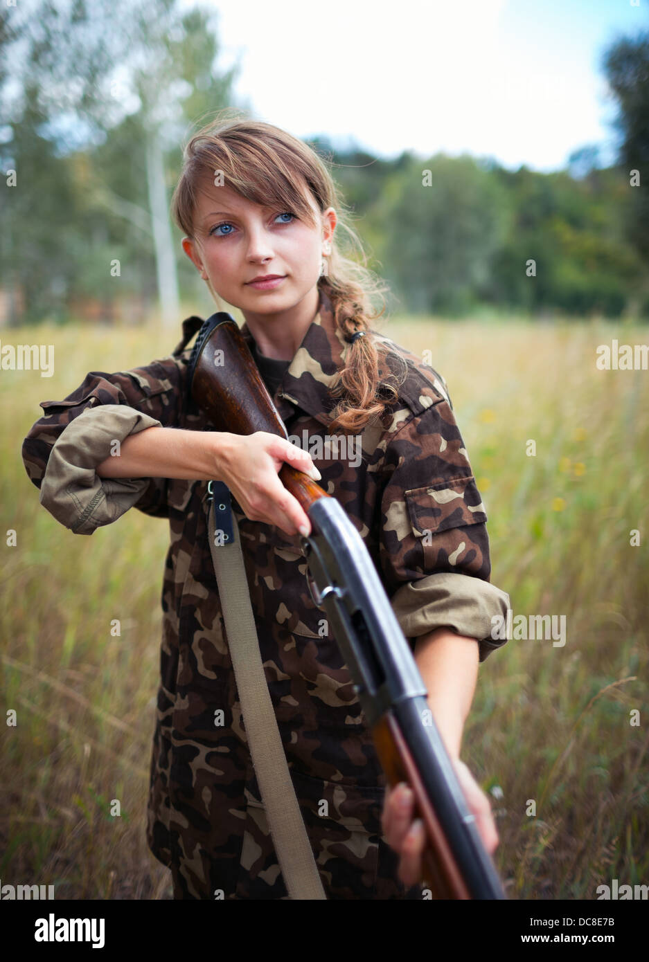 Young beautiful girl with a shotgun in an outdoor Stock Photo