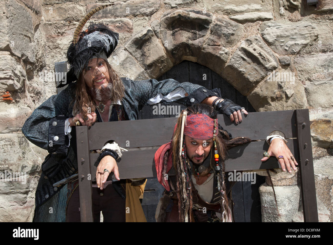 Jack Sparrow and Captain Hector Barbossa, in the village stocks  Children's entertainers at Tutbury Castle event, Derbyshire, UK Stock Photo