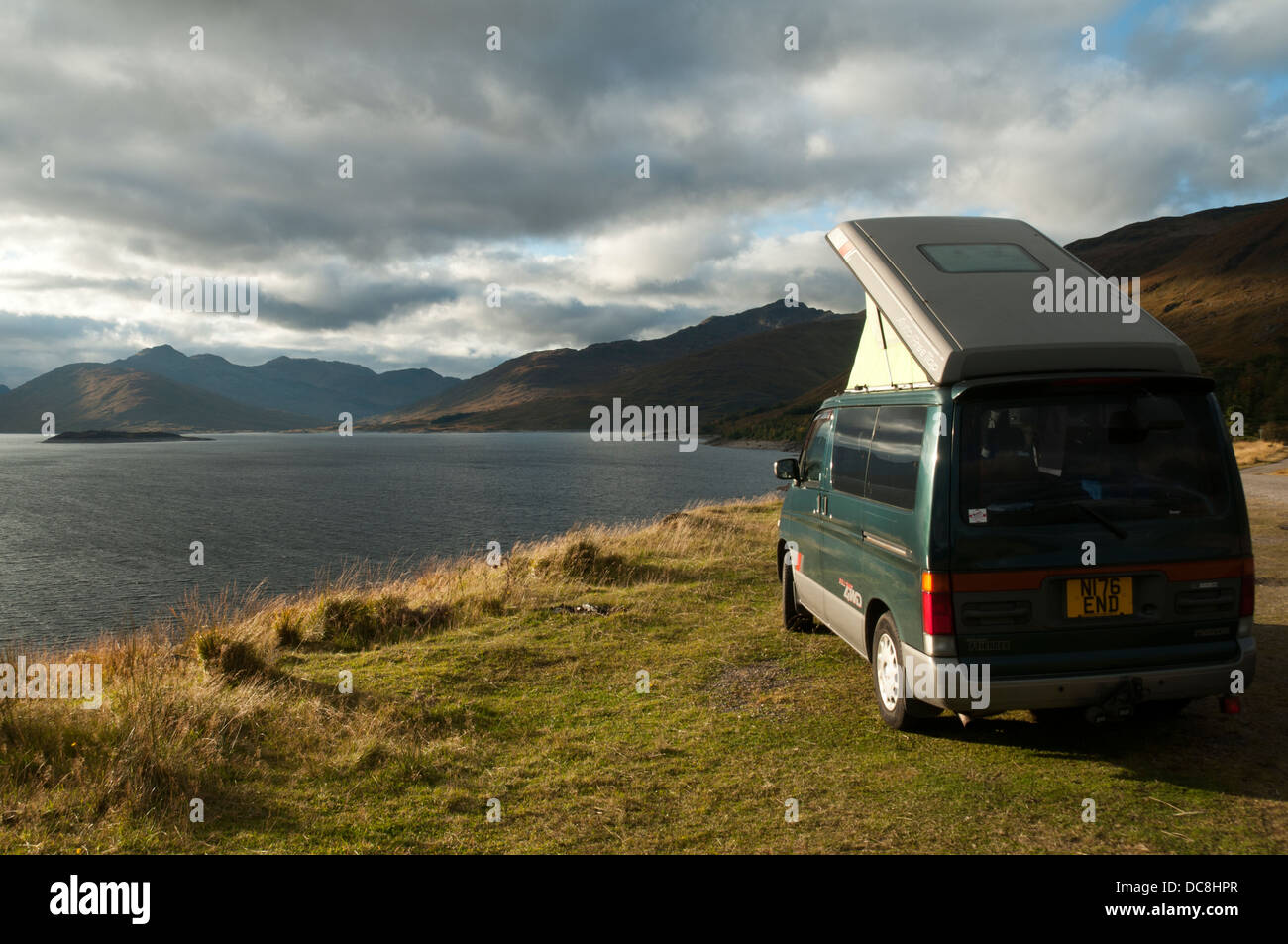 Small motor home camped by Loch Quoich, Highland region, Scotland, UK. The mountains of Knoydart in the distance. Stock Photo