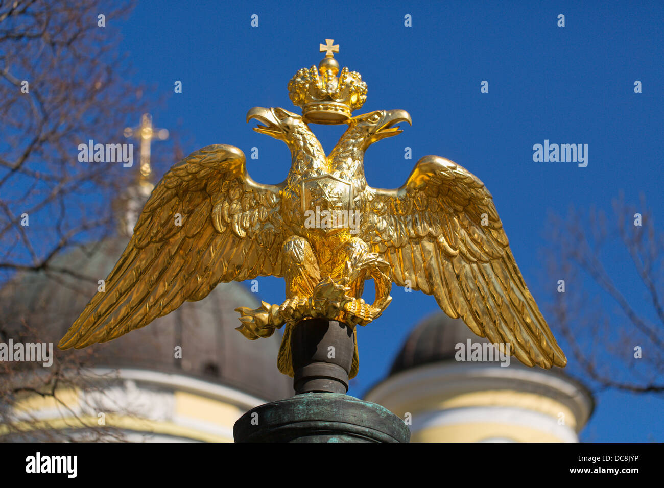 golden double-headed eagle on a background of blue sky and the domes of the church Stock Photo