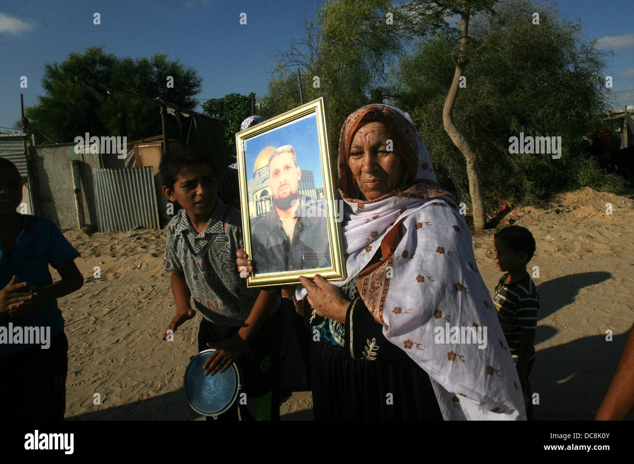 Khan Younis, Gaza Strip, Palestinian Territory. 12th Aug, 2013. The mother of Palestinian Atya Abu Mosa, who has been held by Israel for 19 years, carries his picture after hearing news on the expected release of her son in Khan Younis, in the southern Gaza Strip, August 12, 2013. Israel on Monday named 26 Palestinian prisoners to be freed this week under a deal enabling U.S.-backed peace talks to resume, although Palestinians said these had been undermined by newly announced plans to expand Israeli settlements © Eyad Al Baba/APA Images/ZUMAPRESS.com/Alamy Live News Stock Photo