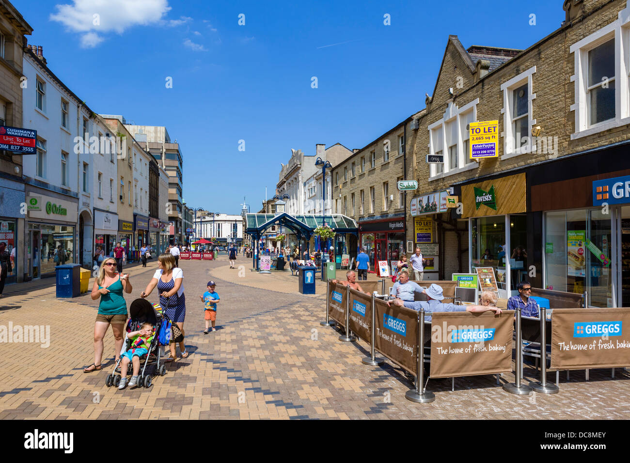 Shops and cafes on the pedestrianised New Street in the town centre, Huddersfield, West Yorkshire, England, UK Stock Photo