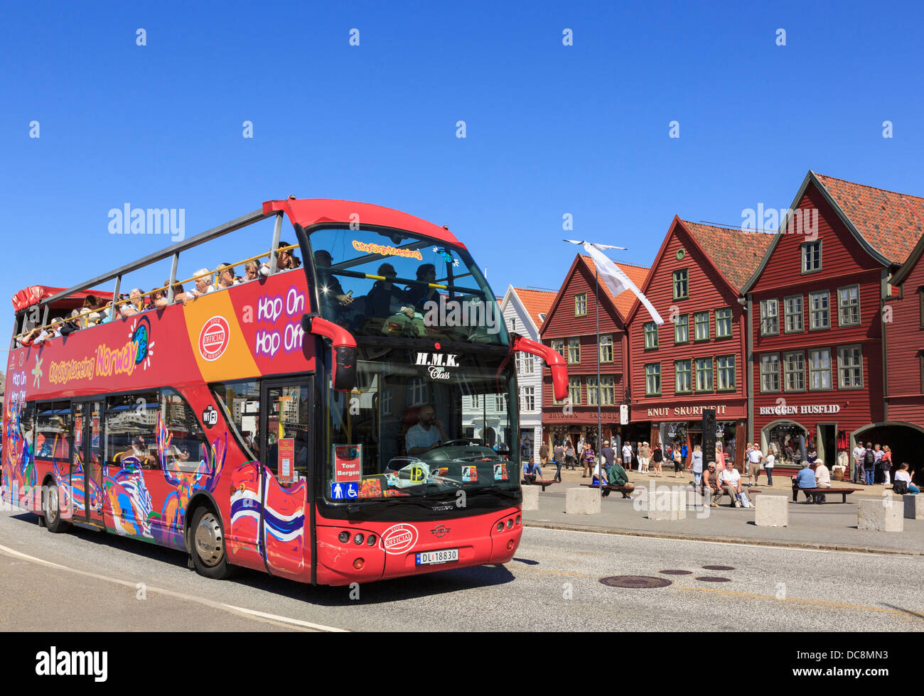 Official tourists' red Hop On Hop Off open top city sightseeing bus in old Bryggen, Bergen, Hordaland, Norway, Scandinavia Stock Photo