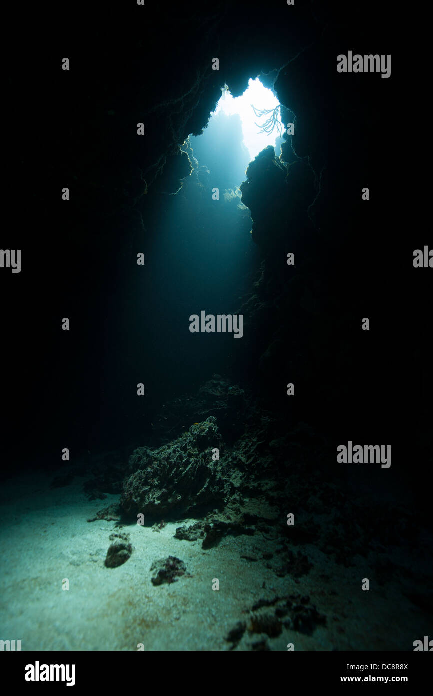 Light beaming into an underwater cave off the island of Roatan, Honduras Stock Photo