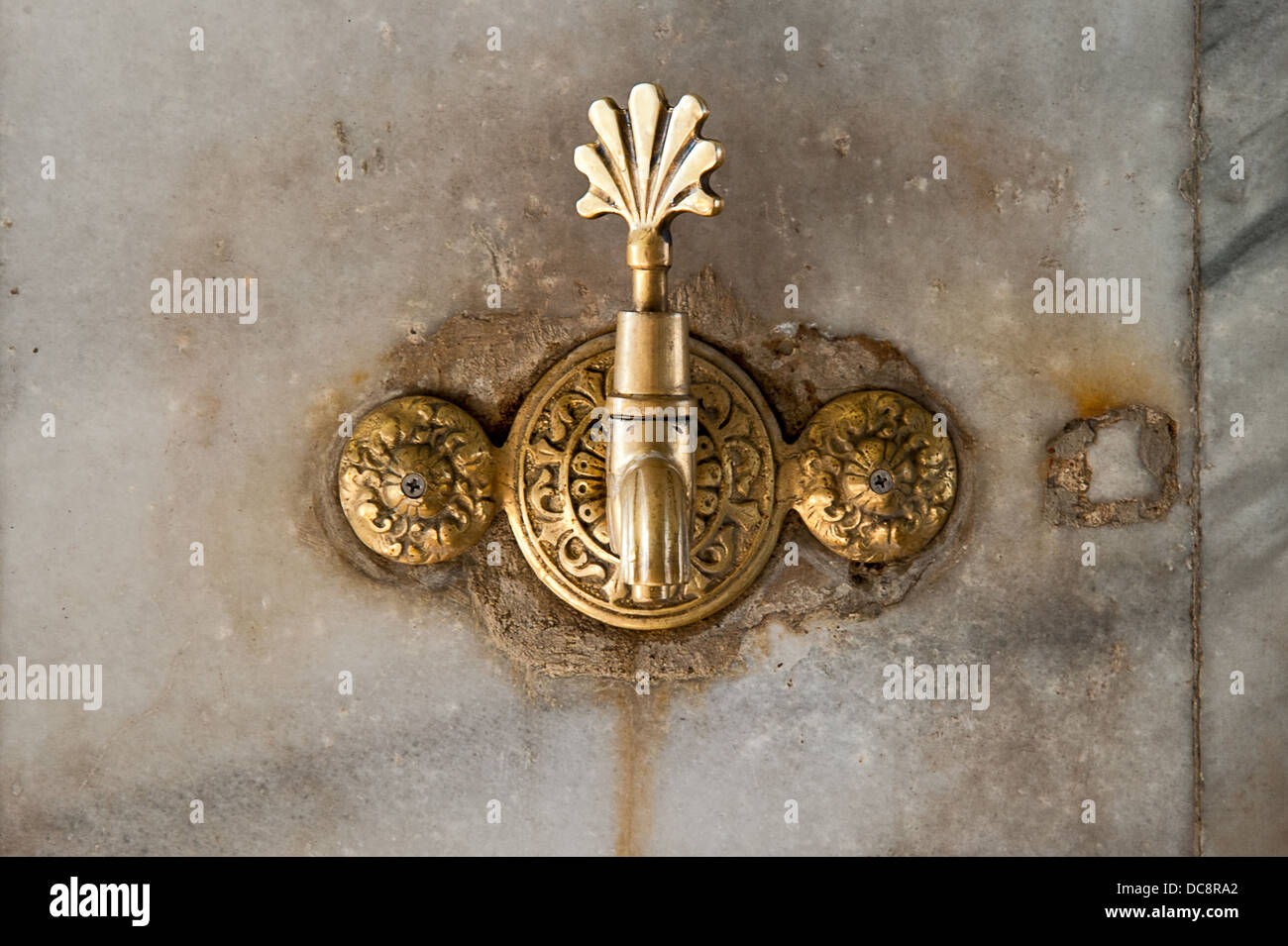 Ornate tap on a marble wall Stock Photo