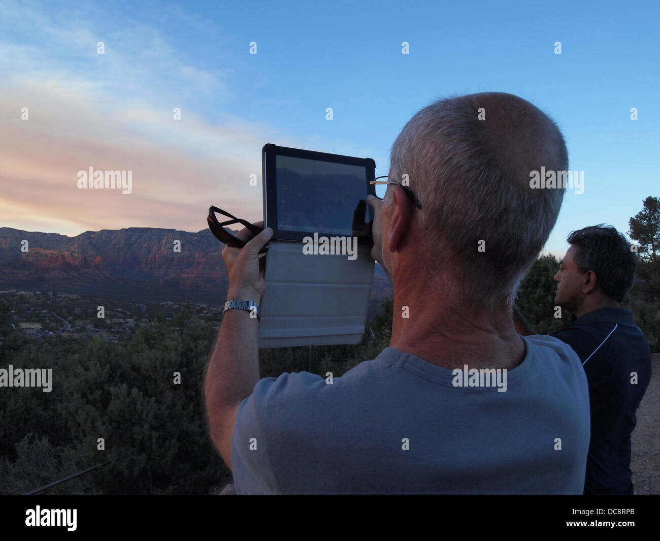 Tourist uses iPad to photograph the scenery from Airport Vista overlook in Sedona, Arizona, USA Stock Photo