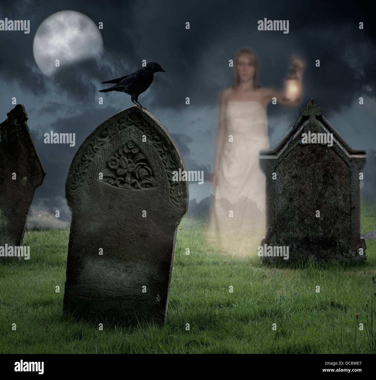 Woman holding lantern haunts cemetery at Halloween Stock Photo