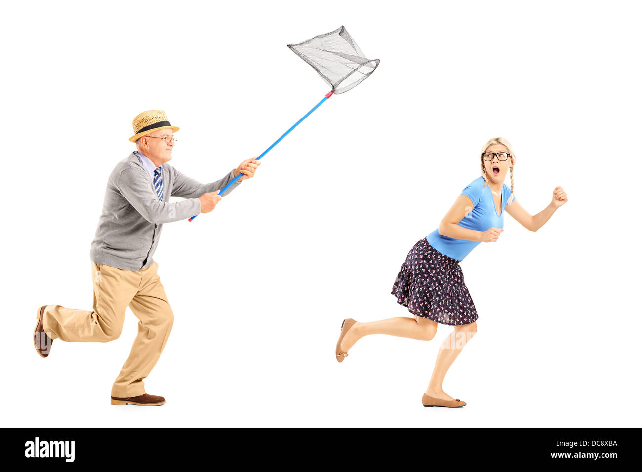 Full length portrait of a scared young female trying to runaway from mature man with butterfly net Stock Photo