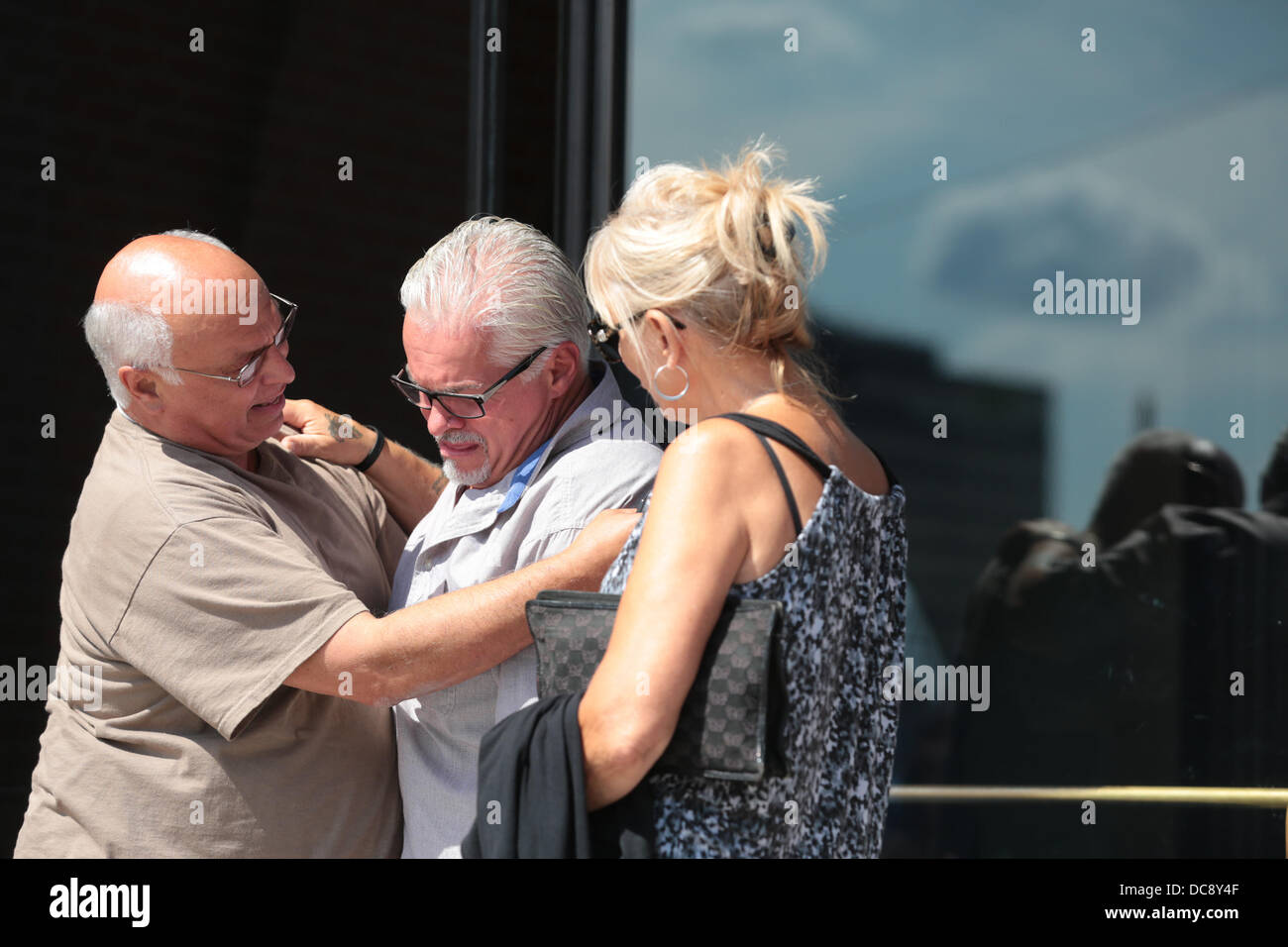 Aug. 12, 2013 - Boston, Massachusetts, U.S. - STEVE DAVIS (C), brother of alleged James ''Whitey'' Bulger victim Debra Davis, breaks down and receives a hug after speaking to the media outside the Moakley Federal Courthouse in Boston regarding his sister's murder and the guilty verdicts in the Bulger trial. Bulger, on the run from the FBI for 16 years, was found guilty of multiple counts of racketeering, conspiracy, money laundering and a string of 11 killings. (Credit Image: © Nicolaus Czarnecki/METRO US/ZUMAPRESS.com) Stock Photo