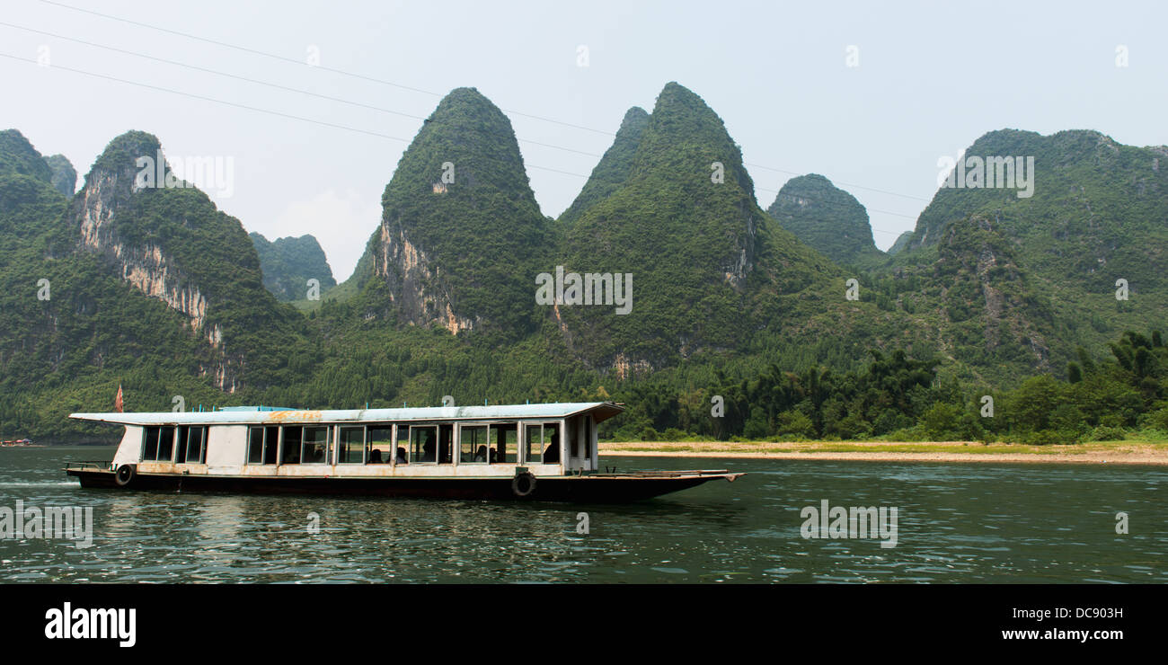 A boat traveling down Li River; Guilin, Guangxi, China Stock Photo