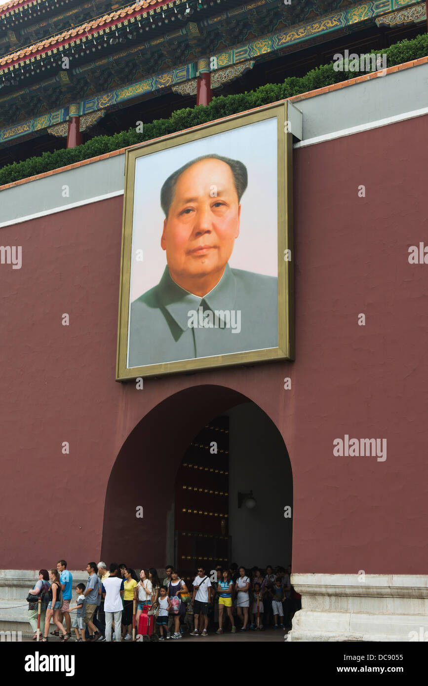 A Group Of Tourists Leave A Building In Forbidden City With A Large Picture Of A Political Leader Over The Arched Doorway; China Stock Photo