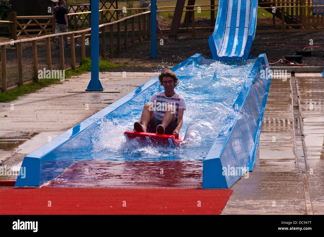 Middle Aged man enjoying himself on a water slide Stock Photo