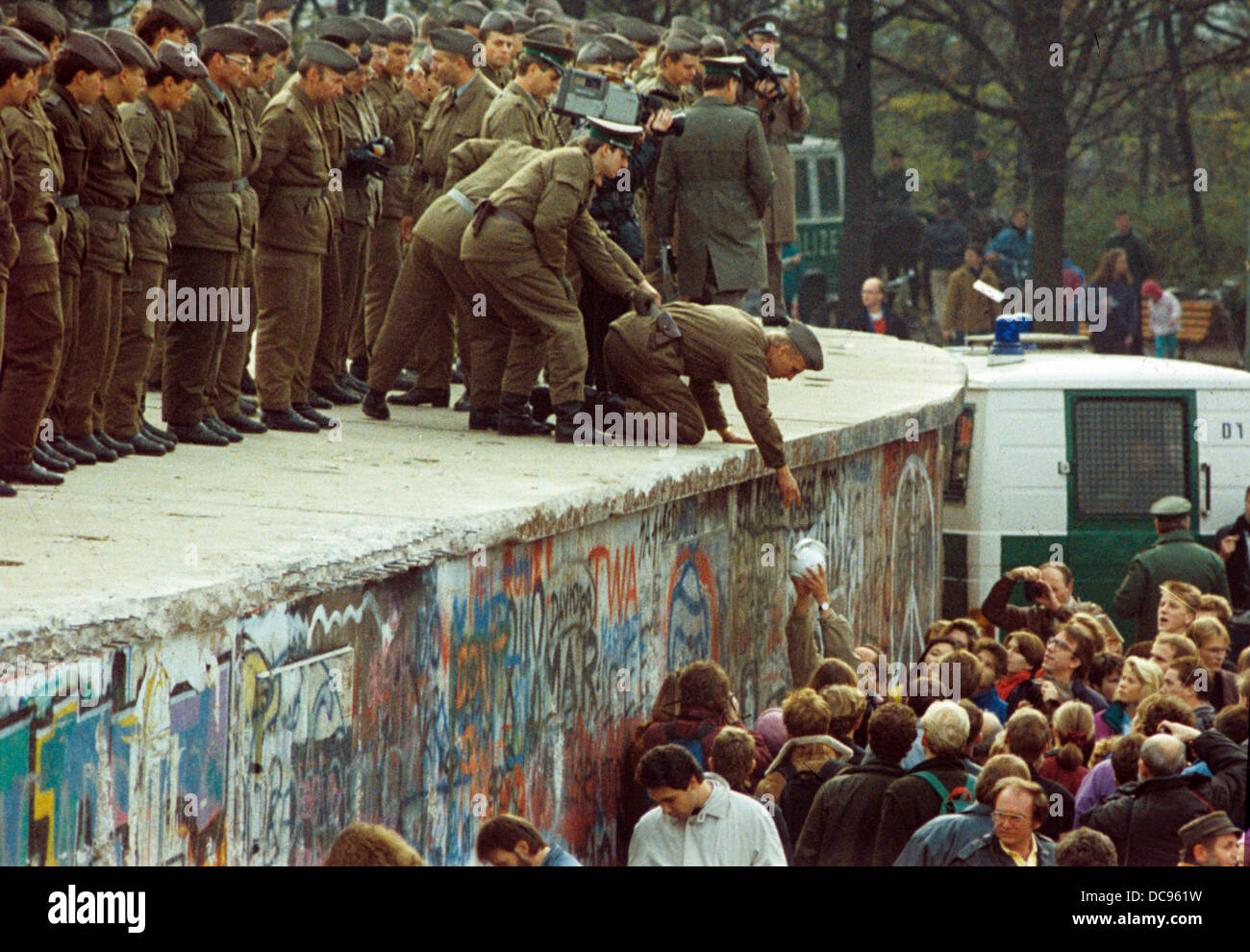 Citizens of West Berlin hand a pot of coffee to GDR border forces on the Berlin Wall, Germany, 11 November 1989. The Wall was opened in the night of 09/10 November. Stock Photo