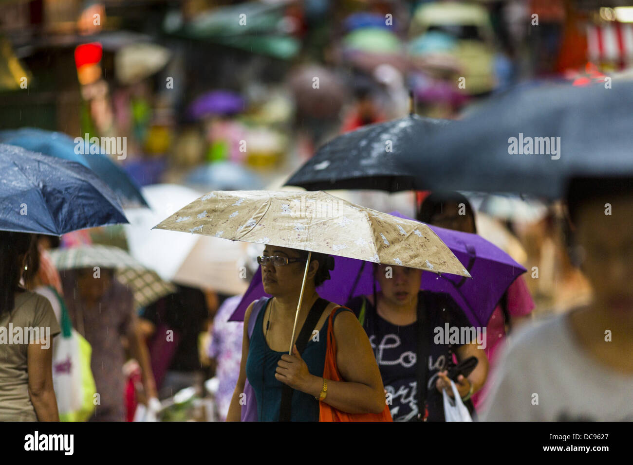 Hong Kong. 13th August 2013.  People shopping on Gage Street in Hong Kong use umbrellas to protect themselves from the rains of Typhoon Utor. Typhoon Utor (known in the Philippines as Typhoon Labuyo) is an active tropical cyclone located over the South China Sea. The eleventh named storm and second typhoon of the 2013 typhoon season, Utor formed from a tropical depression on August 8. The depression was upgraded to Tropical Storm Utor the following day, and to typhoon intensity just a few hours afterwards. Credit:  ZUMA Press, Inc./Alamy Live News Stock Photo