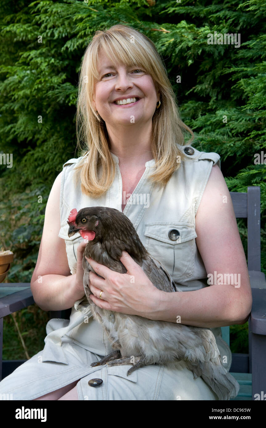 Middle aged Caucasian woman holding Bluebell chicken, taken in garden in Bristol, UK Stock Photo