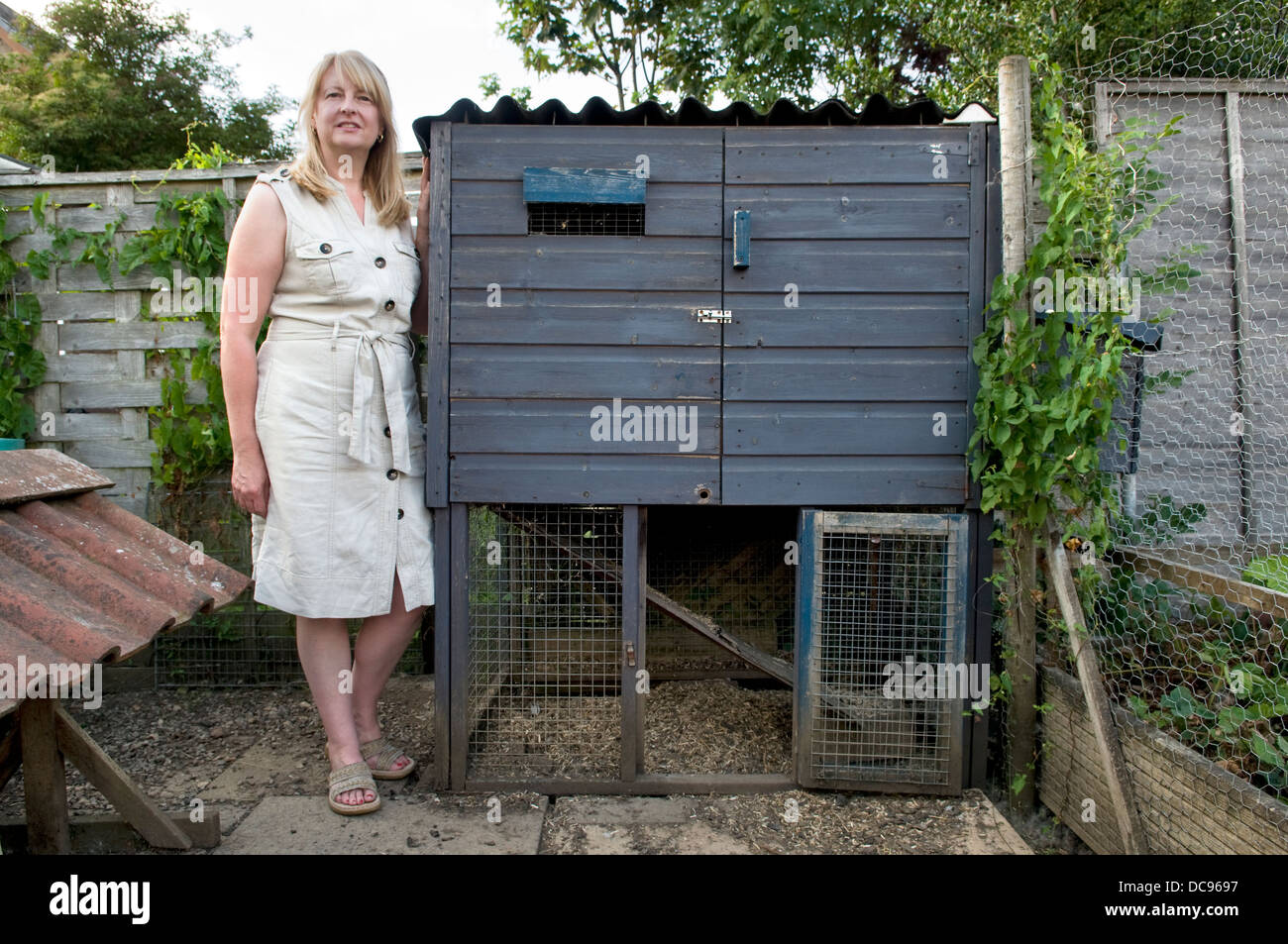 Caucasian woman stood by hen house, taken in garden in Bristol, UK Stock Photo