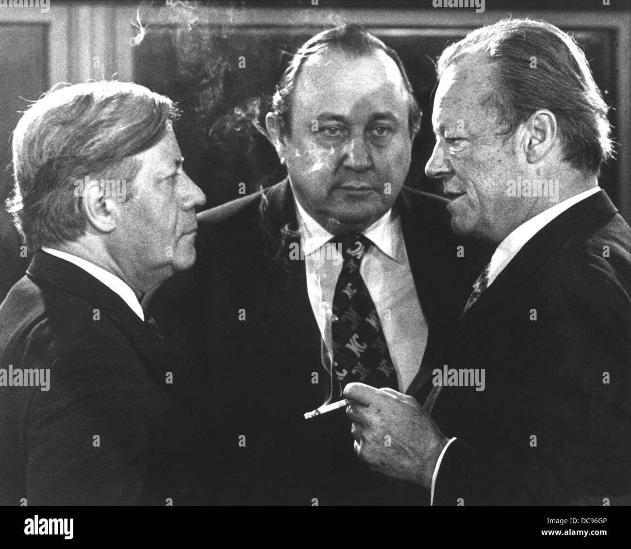 Chancellor Helmut Schmidt (SPD), foreign minister Hans-Dietrich Genscher (FDP) and SPD chairman Willy Brandt (l-r) talk to each other on the 13th of December in 1976 shortly before the beginning of a meeting. Stock Photo